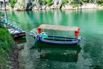 Small tourists transportation Blue boat docked in the small bay at Matka Canyon, Skopje, Macedonia