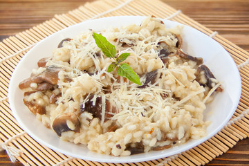 Tasty appetizing risotto on  white plate on  wooden table