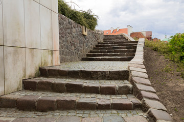 Asphalt staircase of the old city against the background of the fortress wall