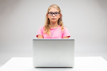 Proud little blond girl seated at her laptop