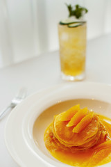 Fototapeta na wymiar Pancakes with orange on a white plate and lemonade