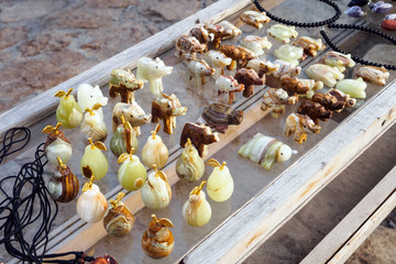 Onyx stone figurines on glass panel on street