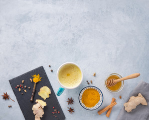 a glass of immune  Golden milk with turmeric, spicy and honey on blue background.