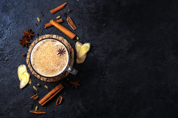 Masala tea with cinnamon and anise on a blue concrete table. A cup of masala tea with spices on the...