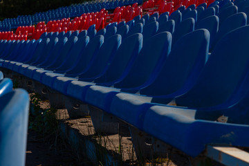 Old plastic chairs stand in rows at stadium