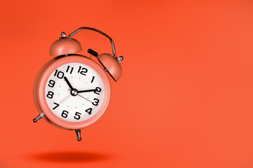 orange alarm clock on orange background