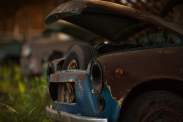 an old rusty abandoned car with an open hood