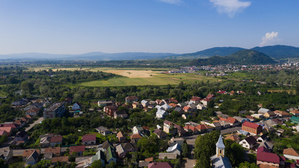 Fototapeta na wymiar Mountain panorama of Mukachevo - view from the drone. Beautiful spring and summer landscape of a small town in Transcarpathia (Ukraine)