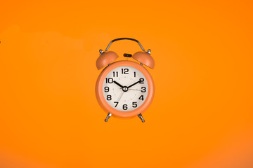 orange alarm clock on orange background