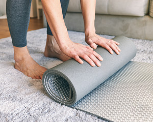 Young woman practicing yoga stretches at home. Unrecognizable person