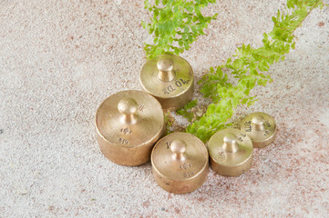 Five antique bronze weights for scales on concrete background.