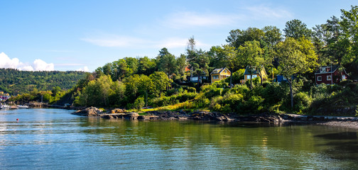 Naklejka premium Panoramic view of Lindoya island on Oslofjord harbor near Oslo, Norway, with Lindoya Ost marina and summer cabin houses at shoreline in early autumn