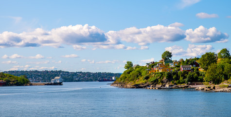 Panoramic view of Lindoya island on Oslofjord harbor near Oslo, Norway, with summer cabin houses at wooded shoreline in early autumn © Art Media Factory