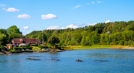 Panoramic view of Lindoya island on Oslofjord harbor near Oslo, Norway, with Lindoya Ost marina and summer cabin houses at shoreline in early autumn