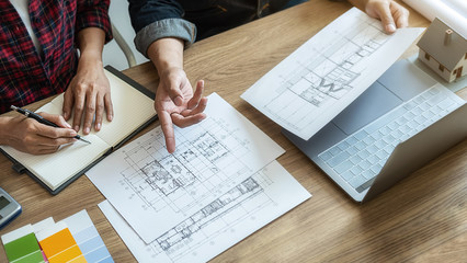 Naklejka premium Interior designer and Architect choosing color in color swatch samples chart for house coloring selection in office with blueprint. Construction concept.