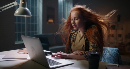 Positively surprised redhead caucasian girl looking at laptop, wing blowing her hair. Model reading breaking news, getting an amazing discount during online shopping or shocked by event 4k footage - Powered by Adobe