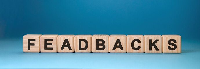 Feadbacks - text concept on wooden cubes with blue background
