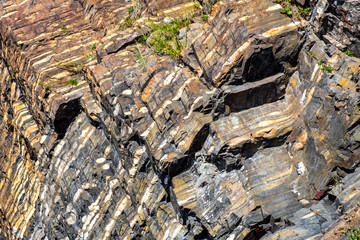 Characteristic, layered rock formation of rocky cliffs of Hovedoya island within Oslofjord Oslo Harbor archipelago near Oslo, Norway.