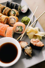 Freshly cooked sushi chef, delicious big rolls with avocado, cheese, salmon, sesame seeds 