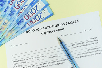 Agreement on the order to create photographic work. Russian text "contract of author's order with the photographer", rubles and pen on the table