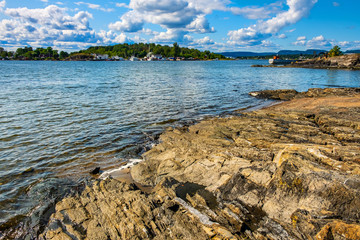 Panoramic view of Oslofjord harbor from rocky recreational cape of Hovedoya island near Oslo, Norway, with Londoya island in background