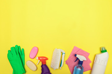 Set of cleaning and detergents, gloves and a brush on a yellow background, space for text. Cleaning. Disinfection. Flat lay.