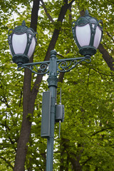 Vintage lantern with surveillance camera in public park, selective focus