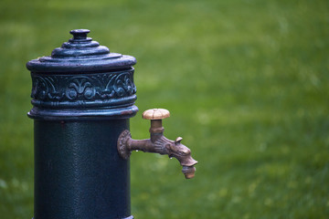 Close-up of old-style column with drinking water in public park, selective focus