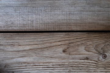 Texture of rough untreated wood close-up. Wooden background. Background of old wooden boards. Two wooden planks of gray and brown with a black gap between them.