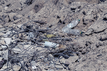 Poured garbage on the beach of a big city. Empty used dirty plastic bottles. Dirty sea, sandy shore of the Black Sea. Environmental pollution. Ecological problem. Plastic trash by the sea