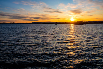 Obraz premium Sunset over Oslofjord harbor with peripheral Oslo Bygdoy peninsula seashore in background near Oslo, Ostlandet region in Norway