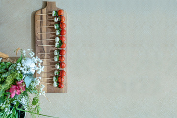 Tabla de madera con brochetas de tomate cherry y mozzarella.  Vist superior. Espacio libre para texto - obrazy, fototapety, plakaty