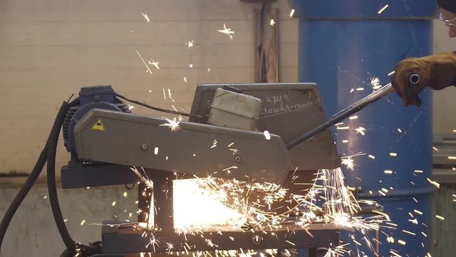Man works circular saw. Flies of spark from hot metal. Chlef and smooth surface. close-up of hand and electric saws metal. Worker cuts a circular saw. Spark particle of metall