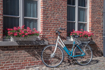 Fototapeta na wymiar The typical Flemish view of the bicycle near old stone house