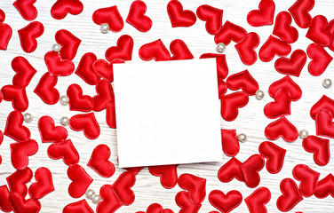 Many small red hearts on a wooden background. With a place for congratulations on a holiday. View...