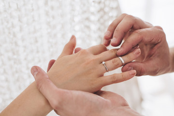 Wedding ceremony.A man puts a wedding ring on a girl's finger. Only hand. Wedding. The husband and wife. Offer. Wedding ring. White skin. Diamond ring. Jewelry.