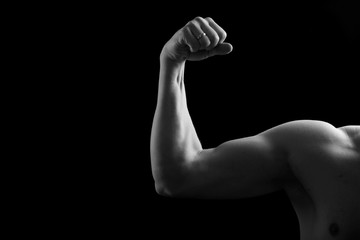 Fototapeta na wymiar Muscular biceps on a black background. Studio shot of the human biceps. Sexy male body. Human hand.