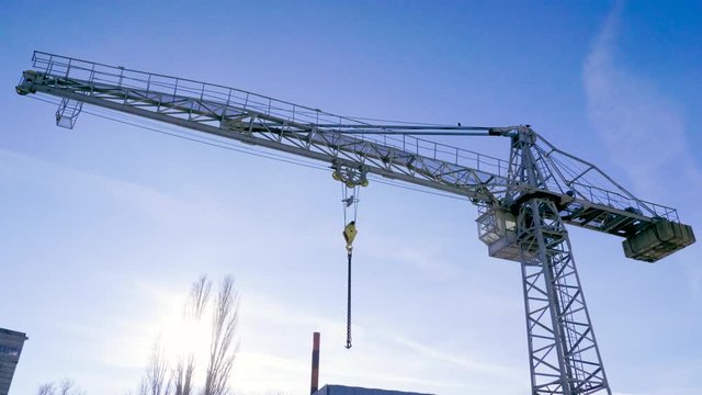 Construction crane against blue sky in the city. 4K