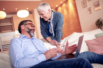 Modern senior couple surfing together