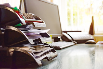 Business documents on an office desk with a printer and computer as a business concept of a workspace. With cloud exposure