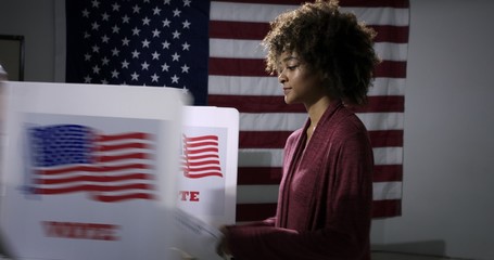 MS Young mixed-race woman ready to vote with blurred voting booth in foreground, being removed....