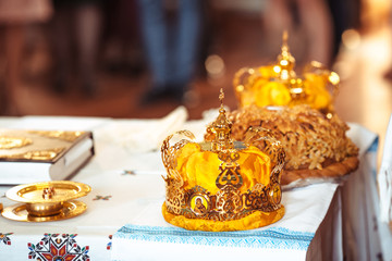 bible and golden crown of newlyweds in the church