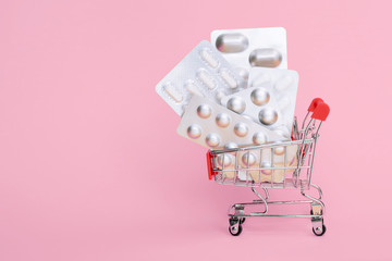 shopping basket with pills, antibiotic isolated on pink. delivery service of online order from pharmacy. female painkiller tablet, menstruation, contraception, climax, pregnancy, progesterone, pms.