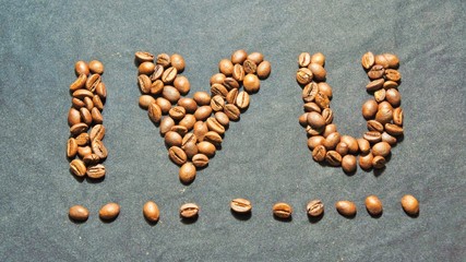 roasted coffee beans on a black background. symbolizes the sign I love you