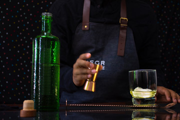 An unrecognizable barman makes a beverage