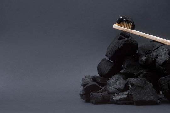 Natural toothpaste activated charcoal and bamboo toothbrush on black  background. Zero waste concept.