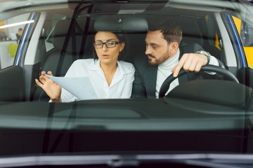 Young business people working together while traveling by a car.