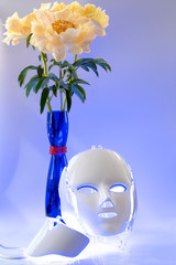 Led mask glowing blue, vase with peonies