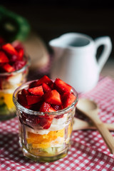 Salade de fruits colorée fait maison dans un verre transparent avec des fraises kiwis bananes et oranges 