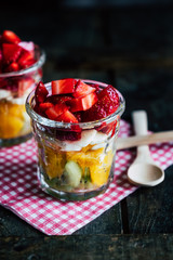 Salade de fruits colorée fait maison dans un verre transparent avec des fraises kiwis bananes et oranges 